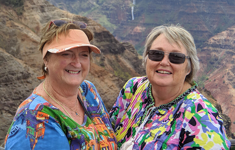 2 smiling ladies taking a picture with the awesome canyon in the background