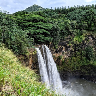 Cascading waterfall over sun soaked cliffs